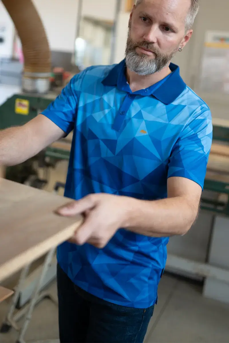 Funktions-Poloshirt mit polygonalem Muster in bunten Farben.